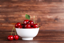 Sweet Cherries In Bowl On Brown Wooden Table