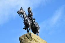 Statue Memorialising The Royal Scots Greys And Their Fight In World War One. Statue Is Of Solider On Horseback On Top Of A Rock. Isolated With Blue Sky Background. Edinburgh, Scotland, UK.