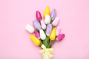 Wall Mural - Bouquet of tulip flowers with ribbon on pink background