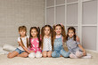 © producer - Group of kid sitting on floor together. four little girls have fun . friendship concept