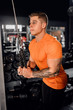© JonoErasmus - Fit young man doing cable tricep extensions in a gym