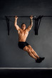 © JonoErasmus - Muscular young man hanging from a gym chin-up bar
