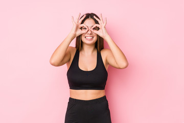 Wall Mural - Young fitness caucasian woman isolated showing okay sign over eyes