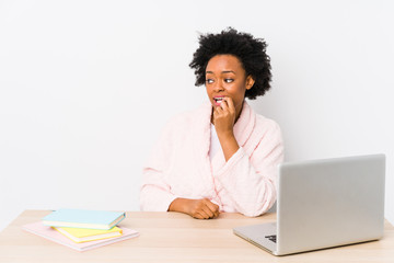 Wall Mural - Middle aged african american woman working at home isolated relaxed thinking about something looking at a copy space.