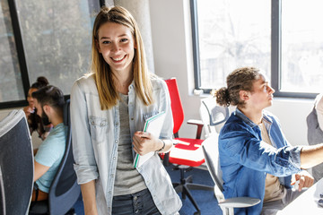 portrait of female programmer and group leader.she standing at the office in front of his workers.