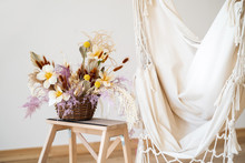 Cozy Beige Hammock In The Interior In The Loft Style And A Flower Arrangement In A Basket With Tulips On A Wooden Staircase.
