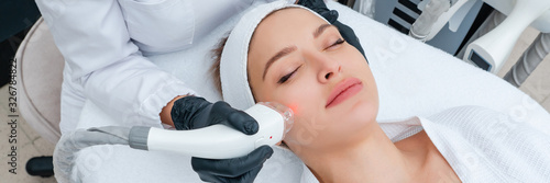 Fotomural Young woman receiving laser treatment in cosmetology clinic