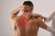 Man suffering from back pain during medical exam. Chiropractic, Physiotherapy, Injury Rehabilitation.