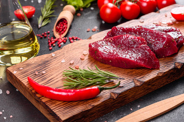 Fresh Raw Beef steak Mignon, with salt, peppercorns, thyme, tomatoes