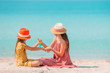 © travnikovstudio - Young mother applying sun cream to daughter nose on the beach. Sun protection