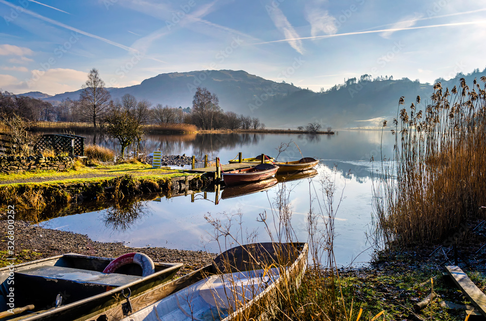 Boats at rest on Grasmere water by the village in the centre of the Lake District Cumbria. .  - obrazy, fototapety, plakaty 