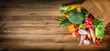 Vegetable dropping out of paper bag on wood background. Top view vegetables photo, copy space fot text.