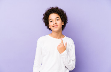 Wall Mural - African american little boy isolated pointing with finger at you as if inviting come closer.