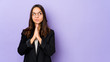© Asier - Young mixed race hispanic woman isolated praying, showing devotion, religious person looking for divine inspiration.