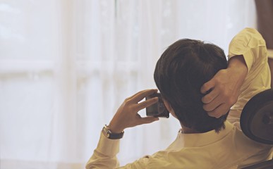 Back view of man talking smart phone in office room.