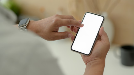 Wall Mural - Close up view of male designer using blank screen smartphone while relaxed from work