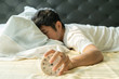 Asian man  wake up in the morning and hand reaching alarm clock