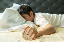 Asian Man  Wake Up In The Morning And Hand Reaching Alarm Clock