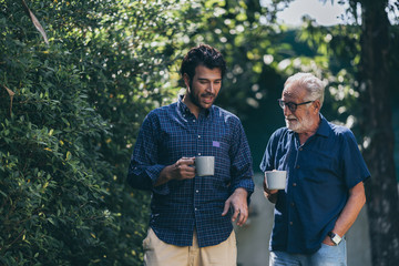 Adult hipster son and old senior father stay for work at home, two generations have a beard talking together and relaxing with smile, happy enjoy living to isolation quarantine at home, father's day