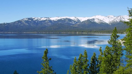 Wall Mural - Turquoise waters of Lake Tahoe in spring with snowy peaks of Sierra Nevada mountains, 4k