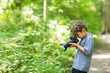 © digitalskillet1 - Young boy taking photo in the forest.