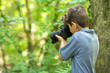 © digitalskillet1 - Young boy taking photo in the forest.