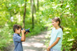 © digitalskillet1 - Young boy taking photo of his sister in the forest.