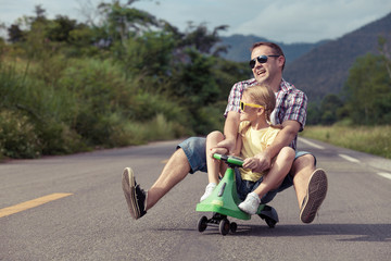 Wall Mural - Father and daughter playing  on the road at the day time.