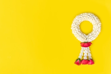 Beautiful thai traditional jasmine garland and rose on yellow background. Symbol of Mother’s day in Thailand. Thai garland made of jasmine and rose for mom.