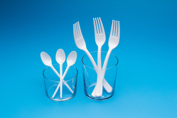 Teaspoon and plastic fork and glass tumbler