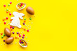 © 9dreamstudio - Sweet Easter symbols - chocolate eggs and bunny gingerbread - on yellow background top-down frame copy space