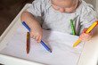 © vickyrandom - Cute baby paint using colorful pencils on white table