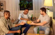 © Syda Productions - friendship, leisure and people concept - male friends drinking beer and eating crisps at home at night