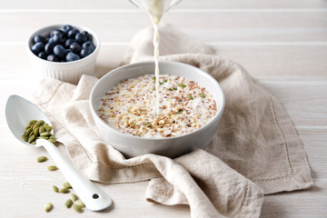 Fresh milk pouring into bowl with granola. Home Fast Breakfast Concept