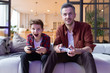 © deniskomarov - Excited boy and smiling father playing video game
