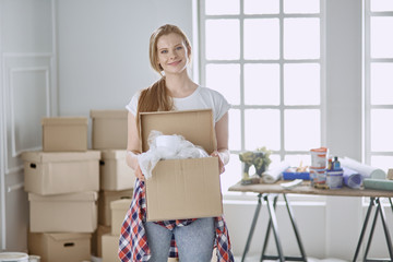 A beautiful single young woman unpacking boxes and moving into a new home