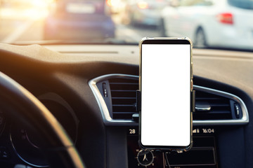 Modern smartphone device gadget mounted on phone holder at car dashboard. Mock-up white screen isolated template. Copyspace for text . Vehicle interior cockpit view. Traffi jam info app