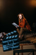 © LIGHTFIELD STUDIOS - selective focus of young actor on stage with clapperboard in front