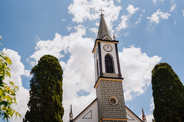 old church with clock, built in the middle of nature, with blue sky in the background