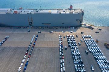 Cars export terminal in export and import business and logistics. Shipping cargo to harbor. Water transport International. Aerial view and top view.