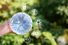 Hand Holding PET Plastic Bottle.Show PET Sign At Bottom Of Bottle,recycle Icon,picking Up Plastic Bottle,PET Icon&Yarn Icon.Save Environment Concept