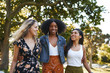 © StratfordProductions - Group of smiling happy multiracial female friends walking together happily in the park on a sunny day