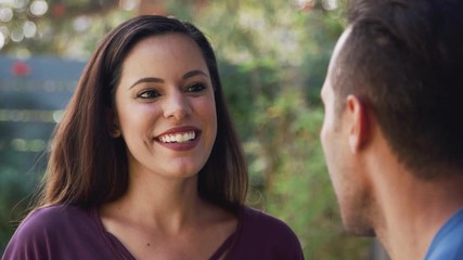 Wall Mural - Smiling Hispanic Couple Talking And Laughing In Garden At Home