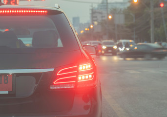 Red car rear lights of the black cars