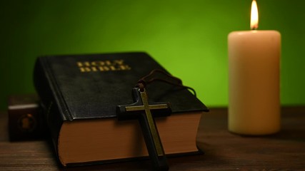 Wall Mural - bible is lying on a table and a candle is burning