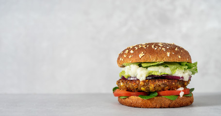 Vegan lentils burger with vegetables on light gray background