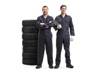 Wall Mural - Auto mechanic workers in uniforms with car tires
