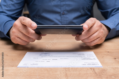 Fotografía Man Taking Photo Of Cheque To Make Remote Deposit