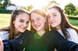 © byswat - 3 girls schoolgirls, selfie photo on phone camera, rest after school weekend. Summer in city, portraits close-up. Emotions of happiness, fun, joy, laughter, smile. Best girl friends. Freckles braces.