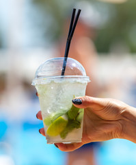 Wall Mural - Girl with a cocktail in hand near the pool